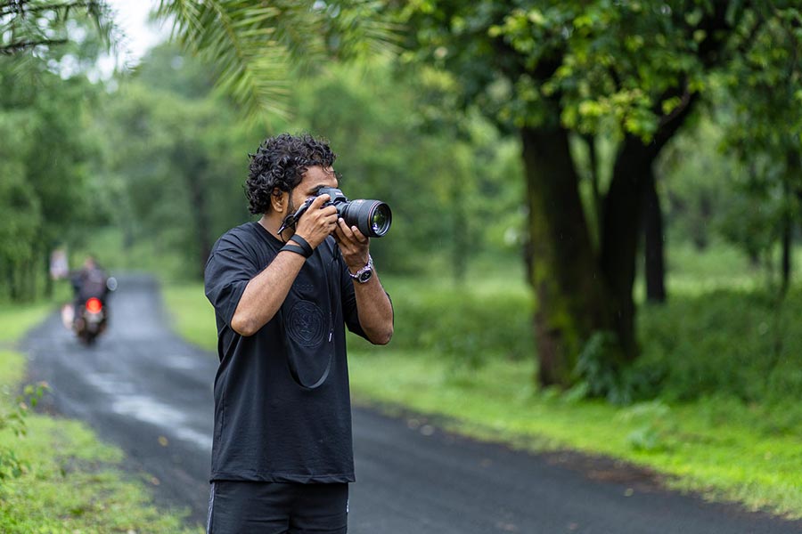 Bablu Khan, a social media maven and photographer, captures images on a wet road amidst green foliage during the Pachmarhi Monsoon Marathon in Madhya Pradesh.