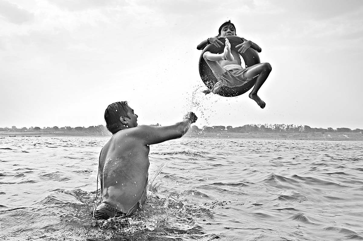 A man and a child is ejoying the Ganga Bath at Varanasi, a photography by Manish-Khattry